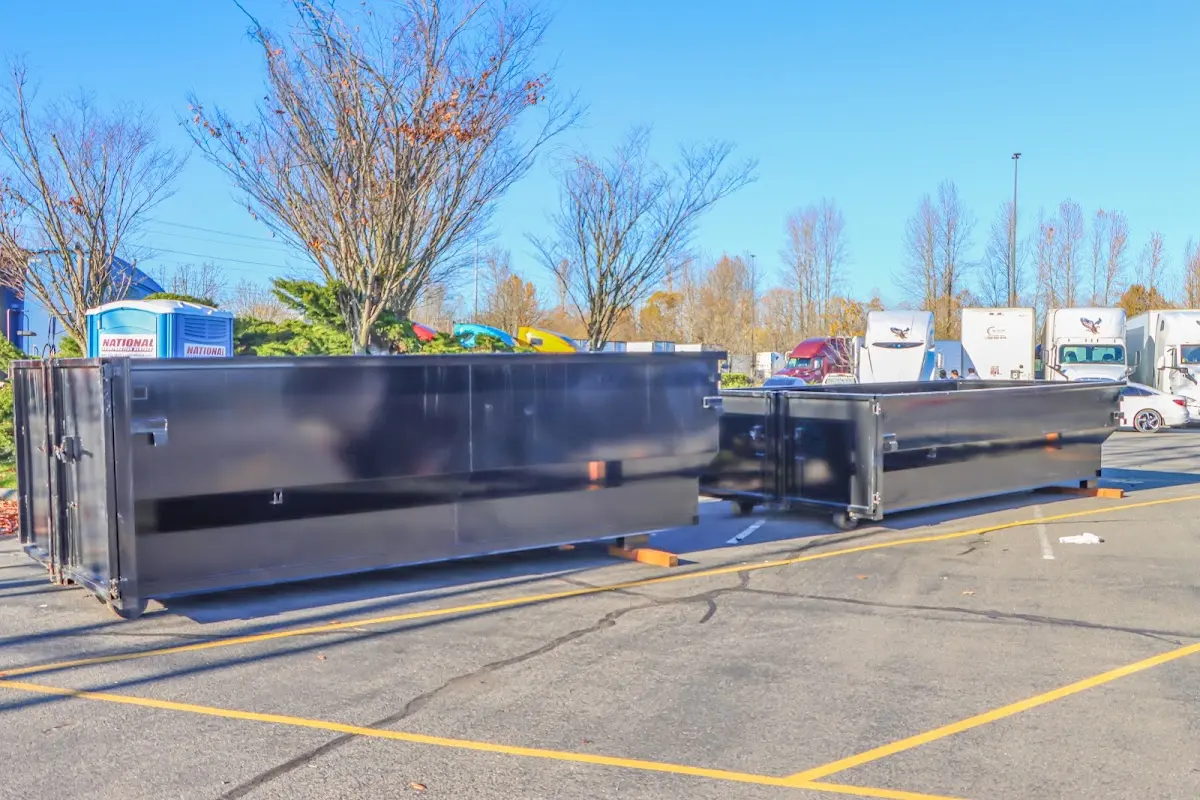 Professional dumpster rental service with roll-off container on residential driveway in Gun Barrel City